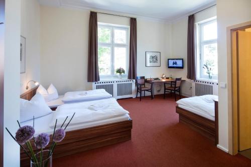 um quarto de hotel com duas camas e uma secretária em Europäische Akademie Berlin em Berlim