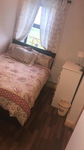 a small bedroom with a bed and a window at The West House in Belmullet