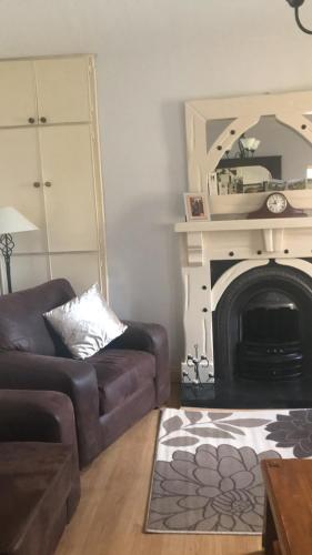 a living room with a couch and a fireplace at The West House in Belmullet