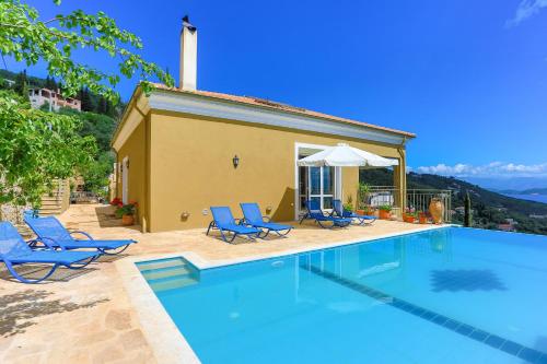 a swimming pool with blue chairs and a house at Villa Rose above Agni with amazing views in Kavalléraina