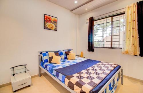 a bedroom with a bed and a window at West Valley Villa in Panchgani
