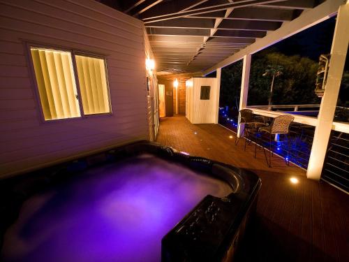 a swimming pool in the backyard of a house at night at White House Ocean View Spa Villa in Burnt Pine