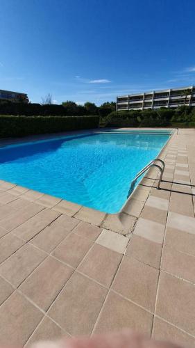 - une piscine d'eau bleue sur une terrasse dans l'établissement Superbe 2 pièces moderne refait à neuf, PISCINE !, à Antibes