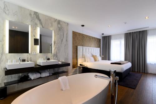 a hotel room with a large white tub at Hotel Rubens-Grote Markt in Antwerp