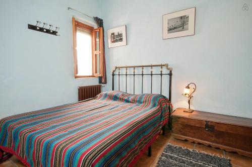 a bedroom with a bed and a lamp on a table at Casa de la Luz in Bubión