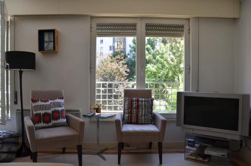 a living room with two chairs and a television at Loft Lambert in Lisbon