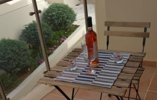 a bottle of alcohol sitting on a table on a chair at Lagada Resort in Makry Gialos