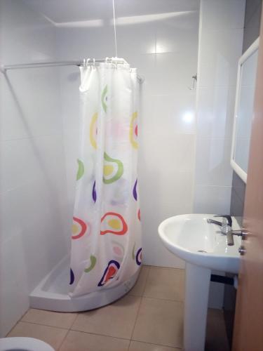 a bathroom with a shower curtain and a sink at Edificio Amanecer in Alcossebre