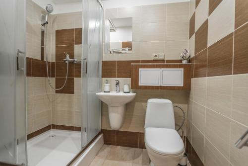 y baño con aseo, lavabo y ducha. en Amos Apartment en Košice