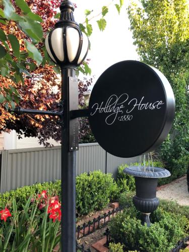 a sign on a lamp post next to a fountain at Hollidge House 5 Star Luxury Apartments in Adelaide