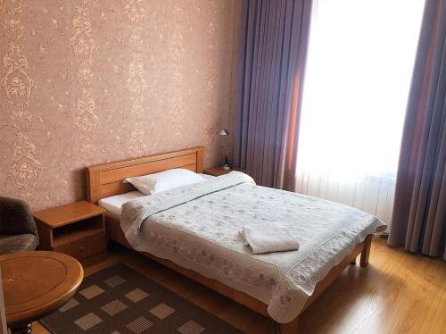 a small bedroom with a bed and a window at Гостиница "Алтын Орда" in Astana