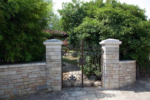 a wrought iron gate with a brick wall at Apartments Ruby in Funtana
