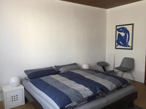 a bedroom with a bed and a chair in it at 3-Zimmer Ferienwohnung Bahnhofsnähe in Fulda