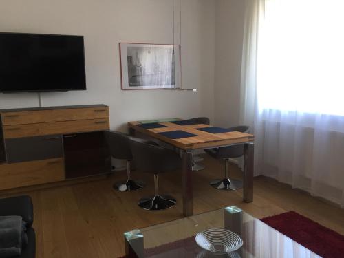 a living room with a table with chairs and a television at 3-Zimmer Ferienwohnung Bahnhofsnähe in Fulda
