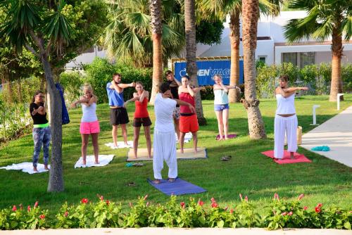 a group of people doing yoga in a park at Cala Llenya Resort Ibiza in Cala Llenya