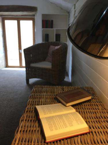 two books sitting on a wicker table in a living room at Le Logis de Limalonges in Limalonges