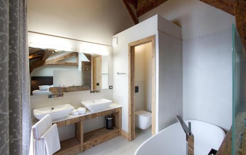 a bathroom with two sinks and a mirror at Odalys Chalet Le Lys in Les Deux Alpes