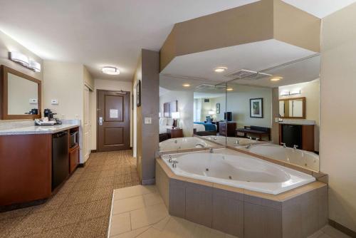 a large bathroom with three sinks and a large tub at Comfort Inn & Suites Northern Kentucky in Wilder