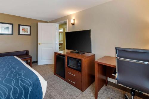 a hotel room with a bed and a flat screen tv at Comfort Inn & Suites Northern Kentucky in Wilder