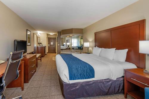 a hotel room with a large bed and a desk at Comfort Inn & Suites Northern Kentucky in Wilder
