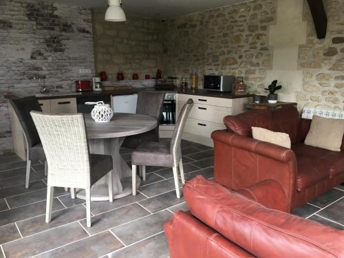 a kitchen and living room with a table and a couch at Oclos du RhuisO in Rhuis