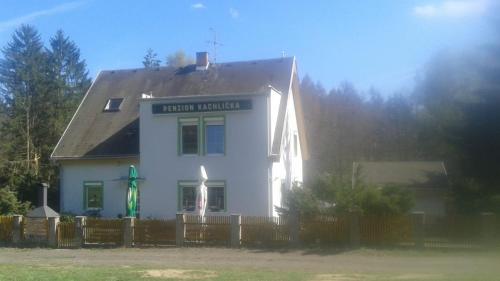 a white house with a fence in front of it at Pension Kachlicka in Skála
