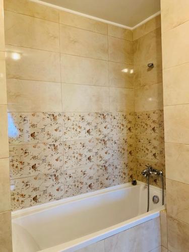 a bath tub in a bathroom with flowers on the wall at Zen Apartment Oradea - FREE Parking in Oradea