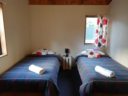 2 Einzelbetten in einem Zimmer mit Fenster in der Unterkunft Awastone in Mangaweka