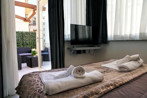 a bed with towels and a television in a room at Le Corti del Re in Naples
