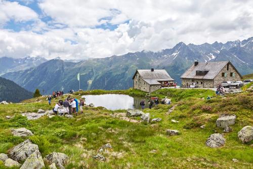 a group of people standing around a small lake in a mountain at Belavita B&B in Ischgl