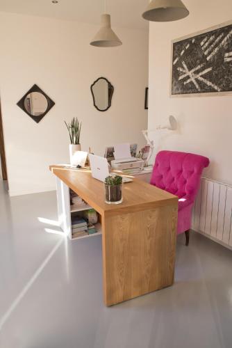 an office with a desk and a pink couch at Hôtel Le 23 in Sauternes