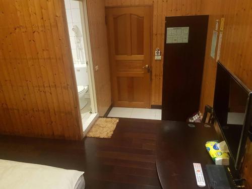 a room with a table and a door to a bathroom at Ming Yang B&B in Fenchihu