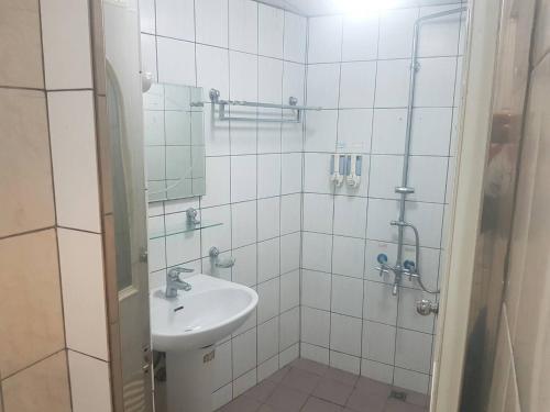 a white bathroom with a sink and a shower at Ming Yang B&B in Fenchihu