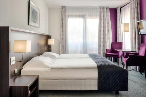 a hotel room with a bed and a table and chairs at Hampshire Hotel - Avenarius in Ruurlo