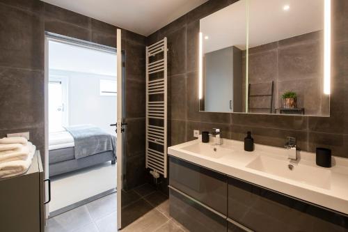 une salle de bain avec un lavabo et un miroir dans l'établissement Longhouse Studio Zandvoort, à Zandvoort