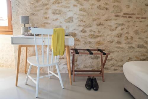 a white desk with a yellow towel on a chair at Hôtel Le 23 in Sauternes