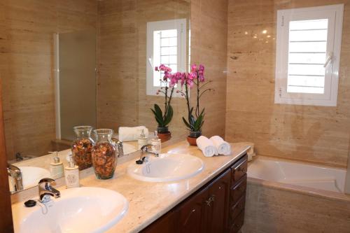 a bathroom with two sinks and a bath tub at Villa Sa Vinyeta in Sant Llorenç de Balafia