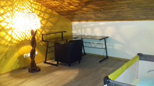 a room with a desk and a lamp and a table at Location meublé a Salazie in Salazie