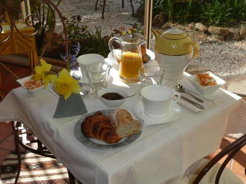 - une table avec petit-déjeuner composé de croissants et de jus d'orange dans l'établissement LES TERRES BASSES, à Fabrezan