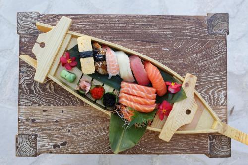 a plate of sushi on a wooden table at Polis 1907 by Louis Hotels in Polis Chrysochous