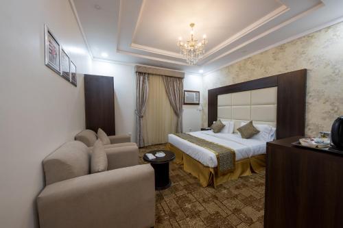 une chambre d'hôtel avec un lit et un canapé dans l'établissement Jasmine Beach Hotel Suites, à Yanbu