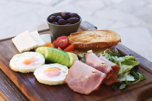 a plate of food with eggs meat and bread and vegetables at Polis 1907 by Louis Hotels in Polis Chrysochous