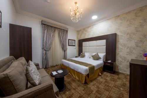 Habitación de hotel con cama y sofá en Jasmine Beach Hotel Suites, en Yanbu