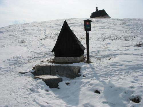 a small house in the snow next to a pole at Penzion Chalupka in Spišské Podhradie