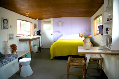 a bedroom with a yellow bed and a sink at Bed in Boat Amsterdam in Amsterdam