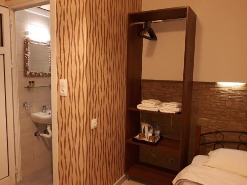 a bathroom with a bed and a sink and a mirror at Hotel Trifylia in Kyparissia