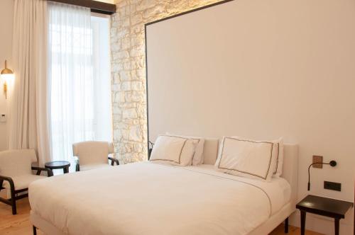 a bedroom with a large white bed with two pillows at S Paul City Hotel in Limassol