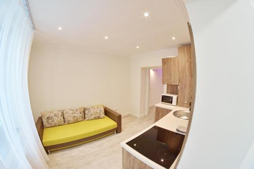 un soggiorno con divano giallo e una cucina di Dimitrie Cantemir Residence a Braşov