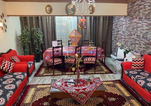 Luxury Apartment City stars في القاهرة: غرفة معيشة مع كنب احمر وطاولة