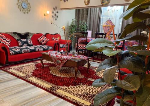 a living room with a red couch and a table at Luxury Apartment City stars in Cairo